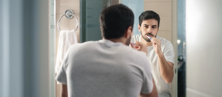 A man brushing his teeth getting ready for bed