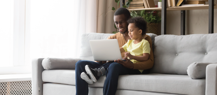 Father and son smiling looking at laptop