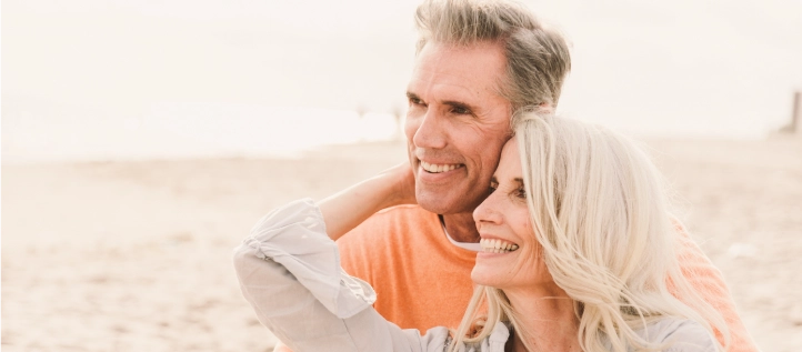 A couple with good oral health, smiling on the beach