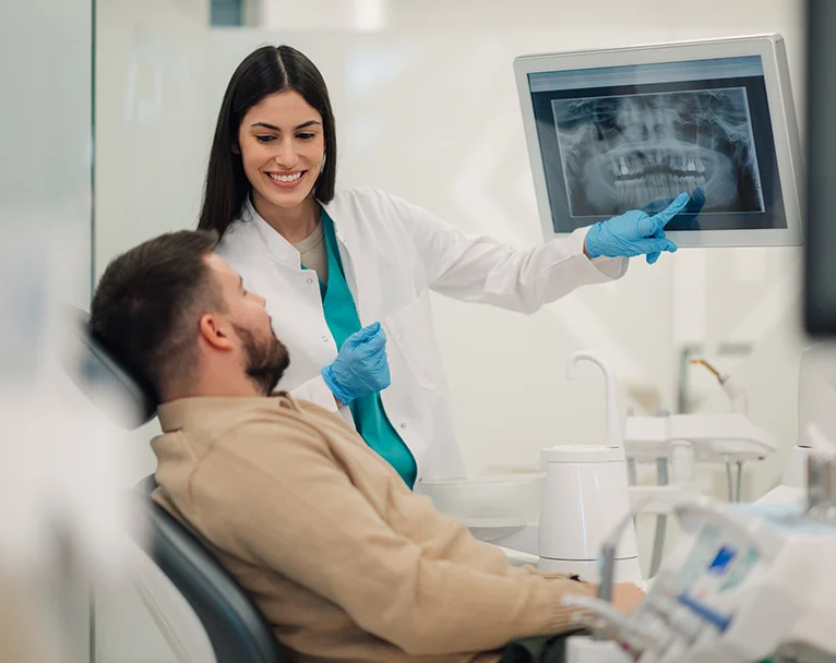 A dentist showing her patient an x-ray for an implant procedure