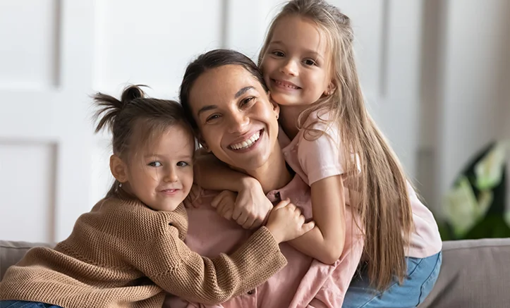 A mother with two young kids smiling about family dental insurance