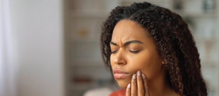 Young woman holding her jaw in pain