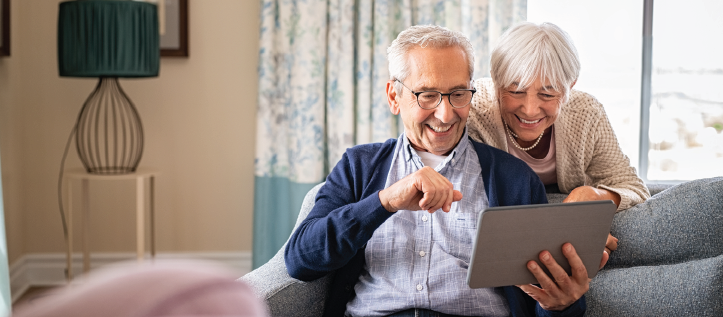 An older couple smiling looking at Spirit Dentals denture care guide