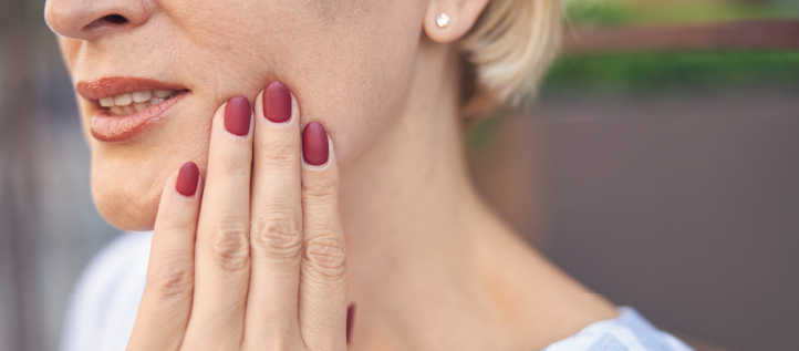 A woman grabbing her jaw in pain