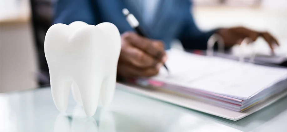 Dentist doing paper work with tooth icon