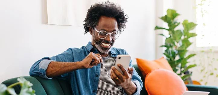 A man smiling researching no waiting period dental coverage on his phone