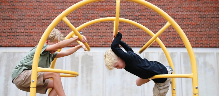 Two kids having fun climbing on a playground