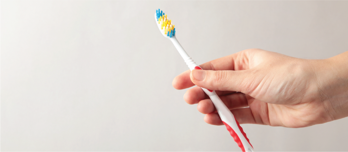 Hand holding up a tooth brush