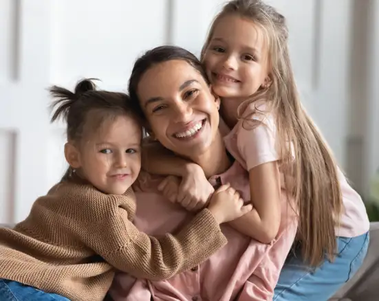 A mother with two young kids smiling about family dental insurance