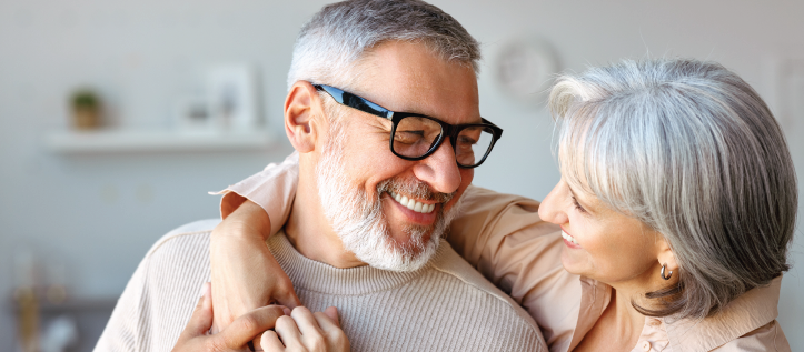 A senior couple smiling while hugging each other