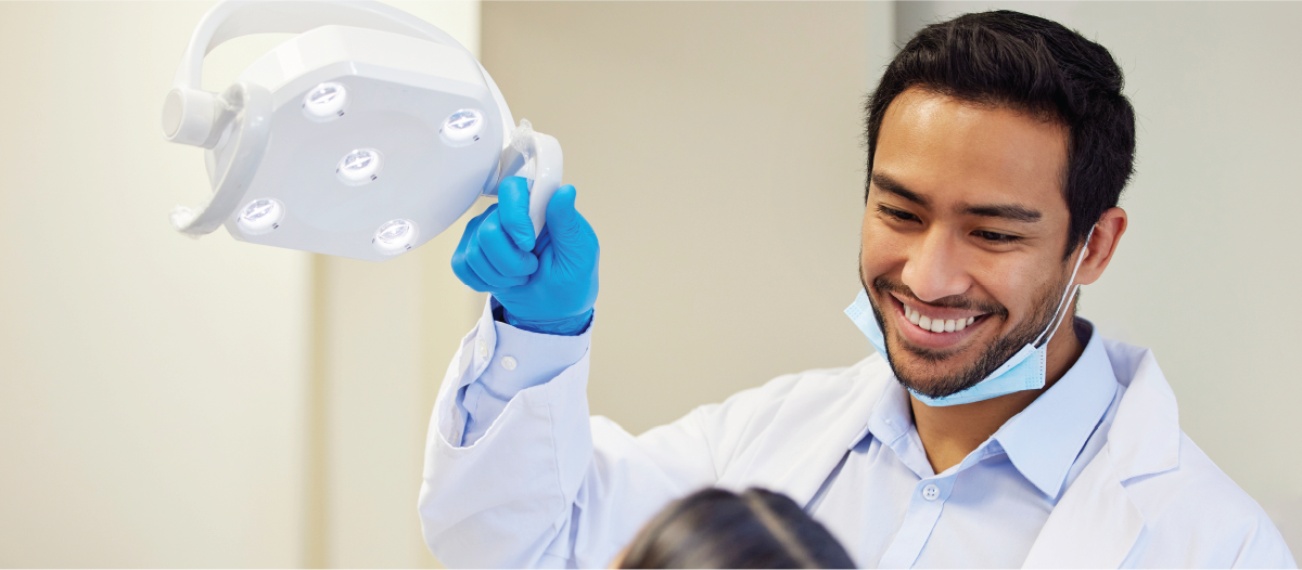 Male dentist smiling down at his patient