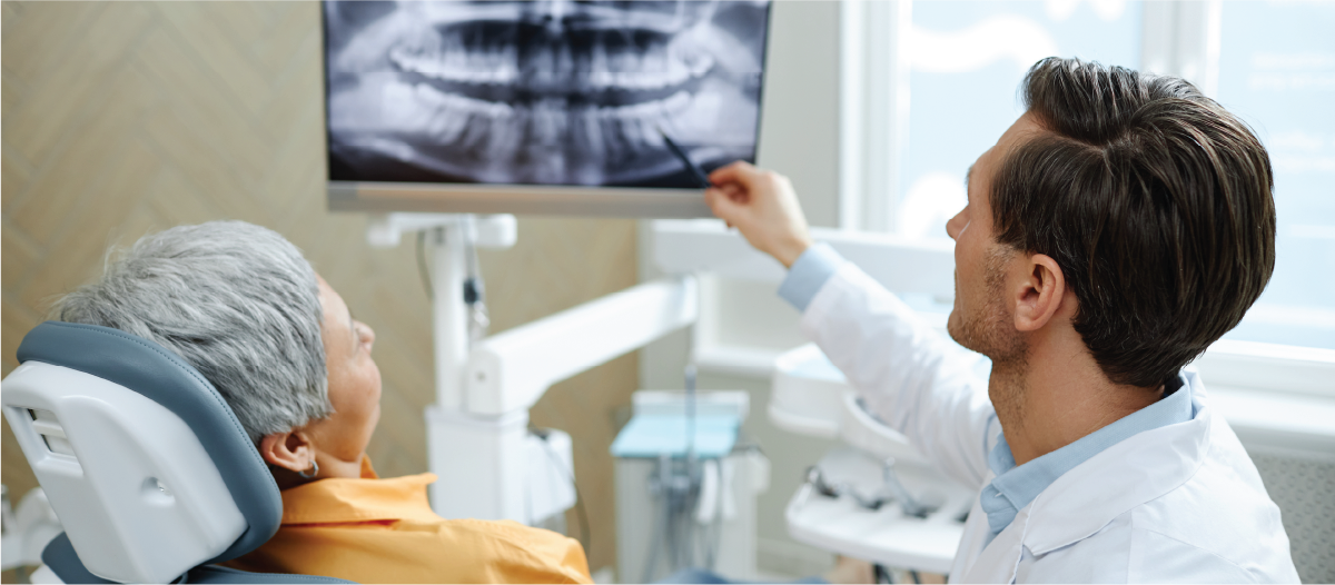 Dentist showing his patient her x-rays at a check up