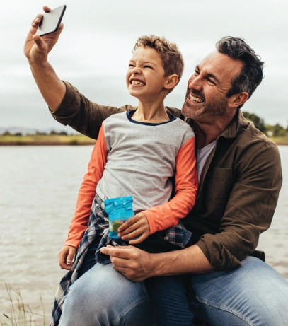 Dad and son smiling at phone