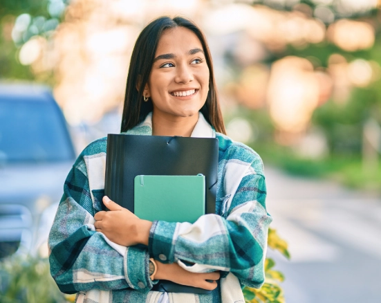 Young college student carrying her books to class