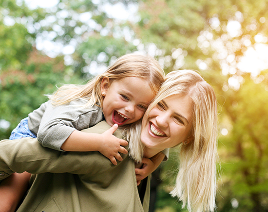 A mother laughing with her child outside.