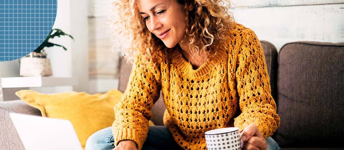 Woman in yellow sweater doing research on a laptop