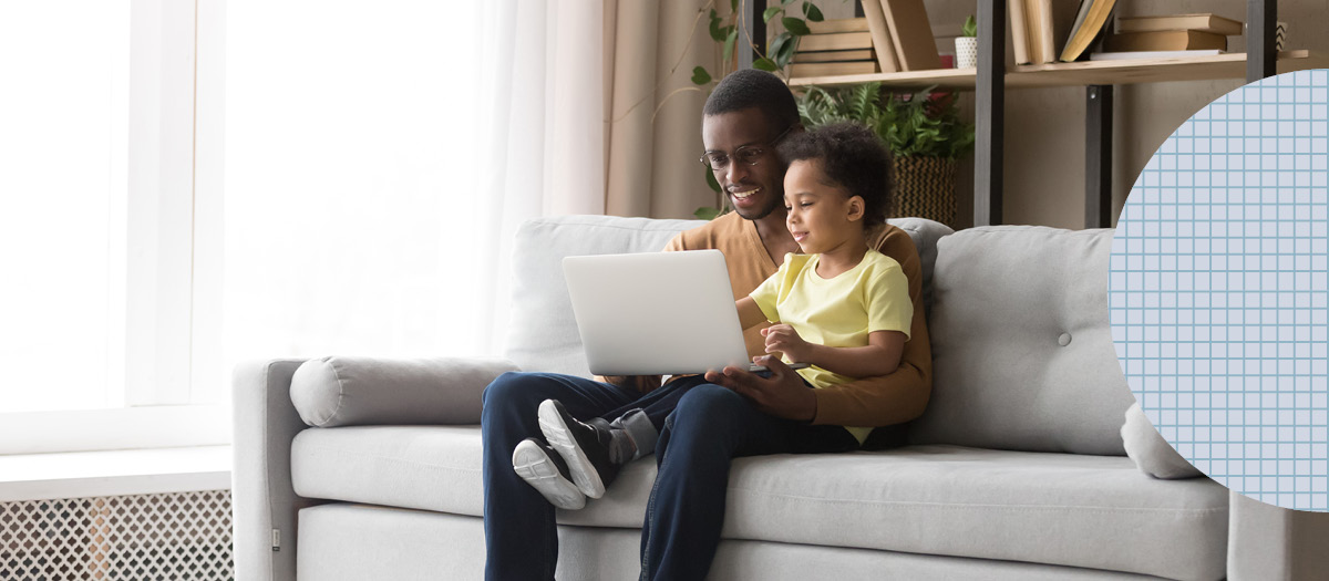 father and son smiling looking at laptop