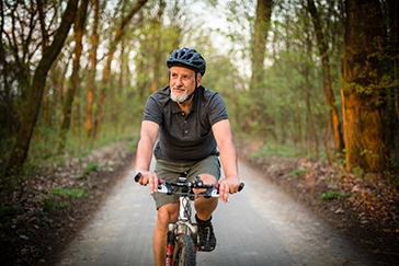 Image of senior man riding bike