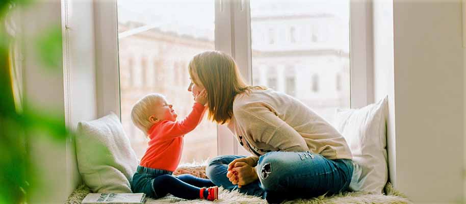 Choosing a Dental Insurance Plan Mom and baby sitting and smiling at each other