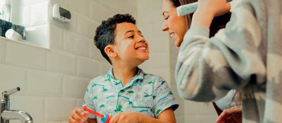 Dental Insurance For Kids Child brushing teeth in bathroom with his mom
